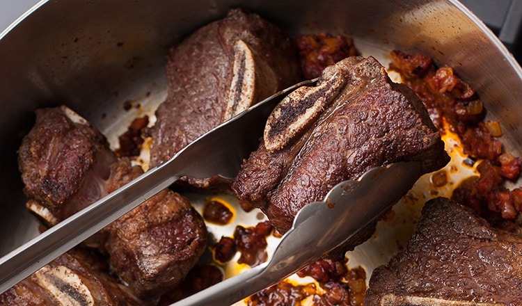 returning seared short ribs to the pot