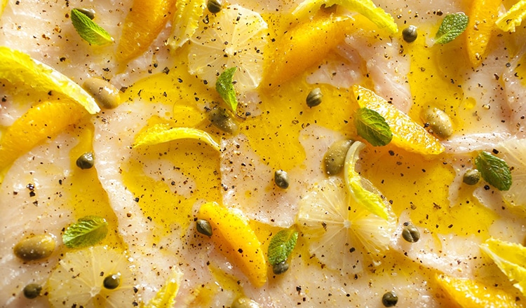 Raw Sworfish thinly sliced and seasoned with citrus, Olive Oil, salt, black pepper and mint