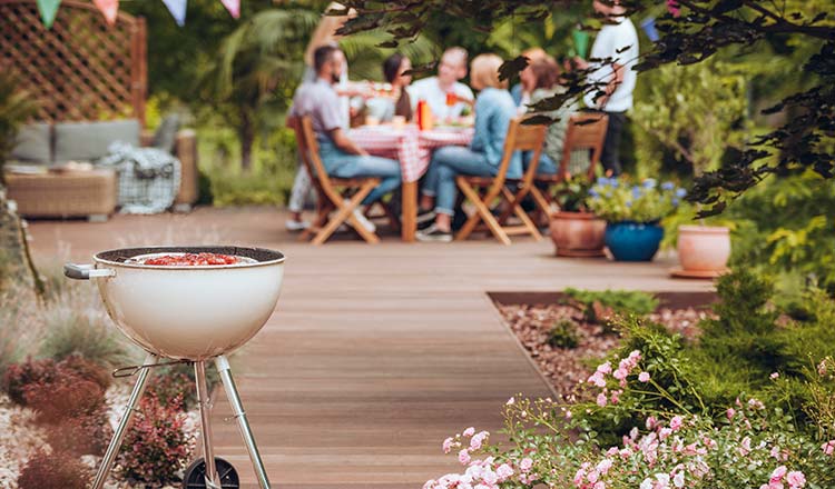 grill in foreground, party behind