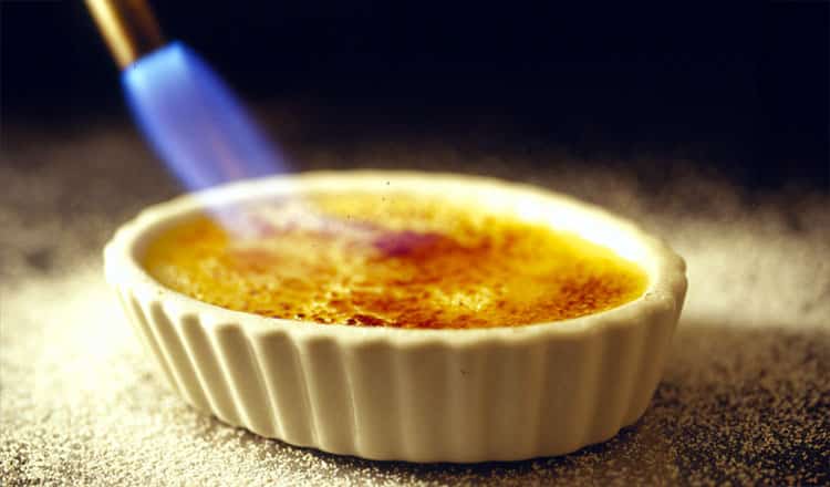 Brûléeing sugar on creme brulee