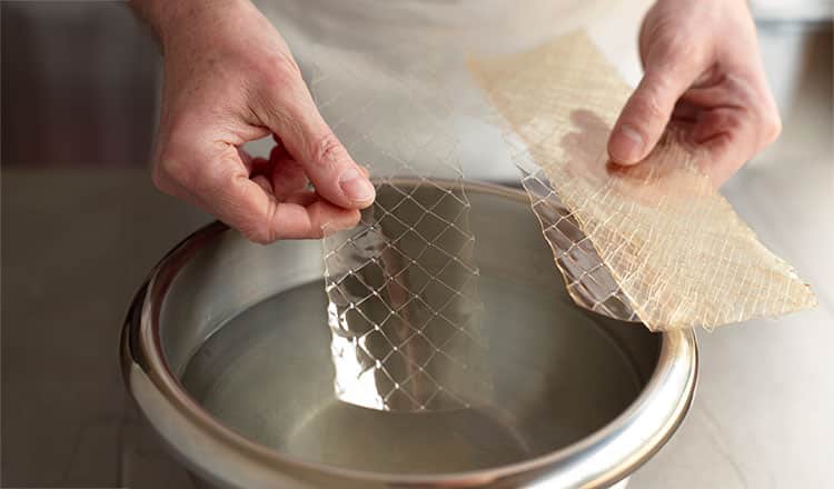 Placing sheet gelatin into a bowl of ice cold water