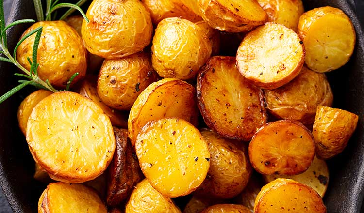 Roasted potatoes with a sprig of rosemary