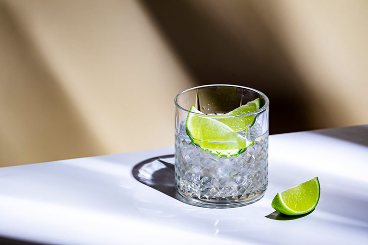 Crystal glass with gin and lime wedges