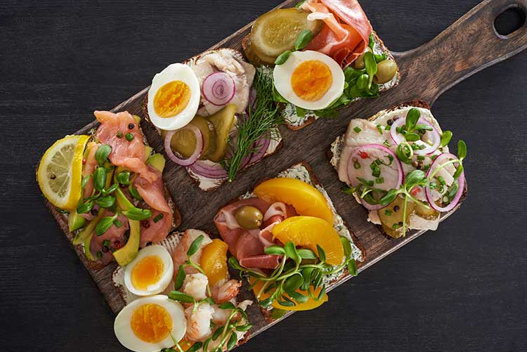 Assorted open faced sandwiches on a cutting board