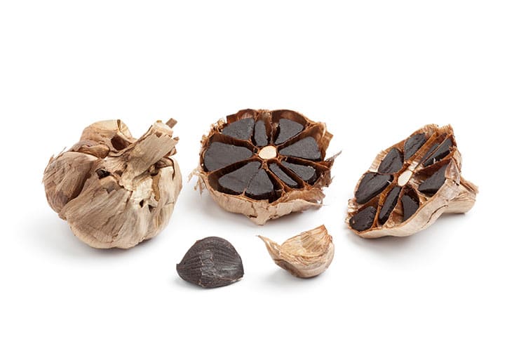 A head of black garlic cut in half